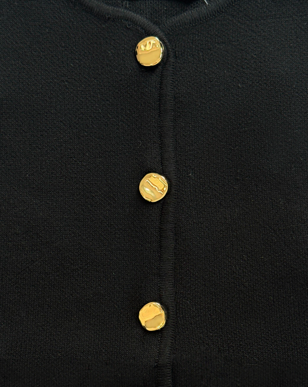 detalle de chaleco negro de punto, estilo clásico