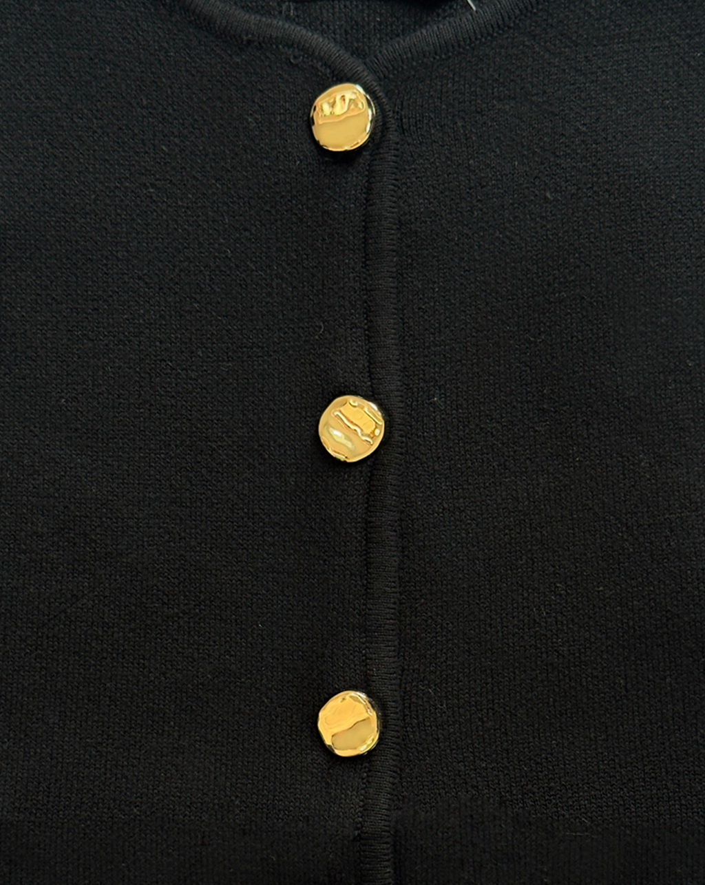 detalle de chaleco negro de punto, estilo clásico